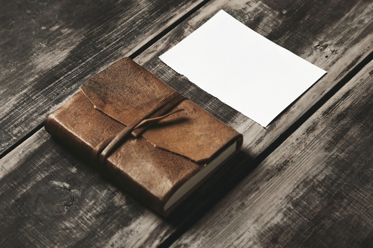 closed-notebook-geniune-leather-cover-near-sheet-white-paper-black-farm-vintage-brushed-wooden-table